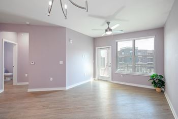 an empty living room with pink walls and a ceiling fan